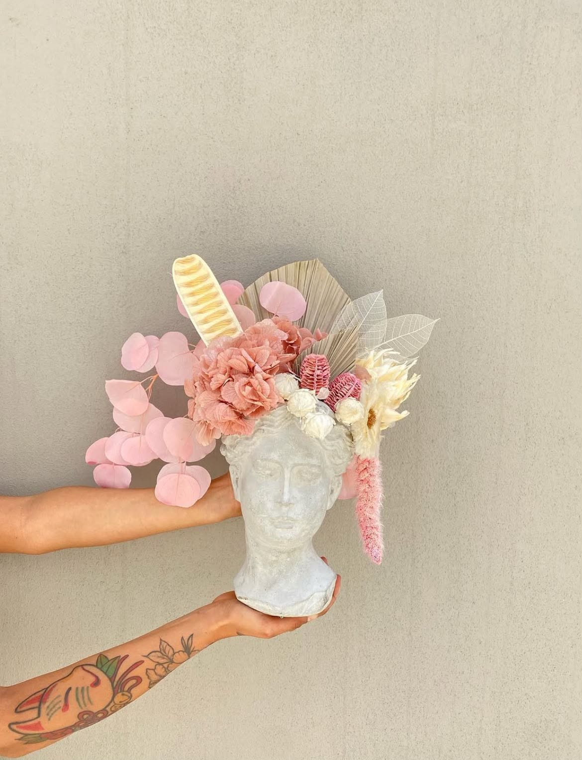 Arreglo floral en jarrón de busto, tonos rosa