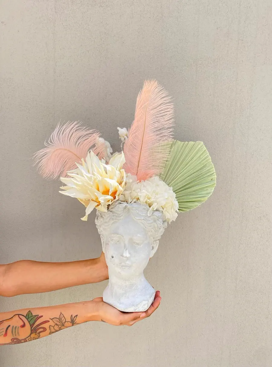 Busto clásico con dalia crema, palma verde salvia y plumas durazno