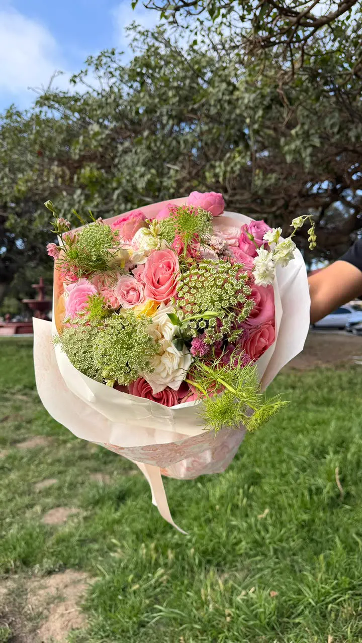 Ramo pastel de peonías y rosas en papel rosa claro